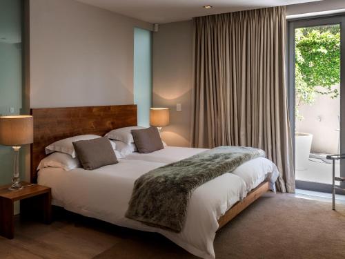 开普敦蓝色视野别墅公寓的一间卧室设有一张大床和一个大窗户