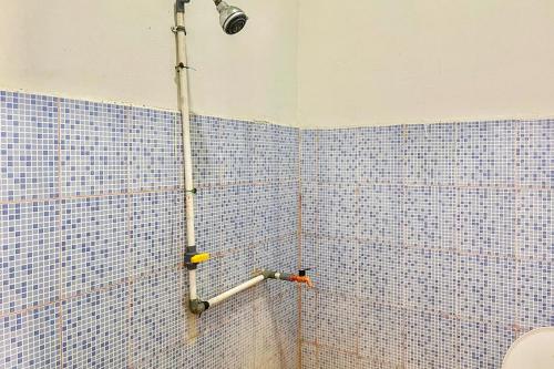 EkasEkas Beach Guesthouse Mitra RedDoorz的浴室设有蓝色瓷砖墙壁和淋浴。