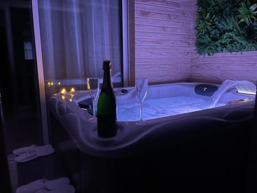 迈阿密普拉特亚JACUZZI PRIVADO y BARBACOA EN VILLA PARADISE的浴缸内备有一瓶葡萄酒和两杯酒