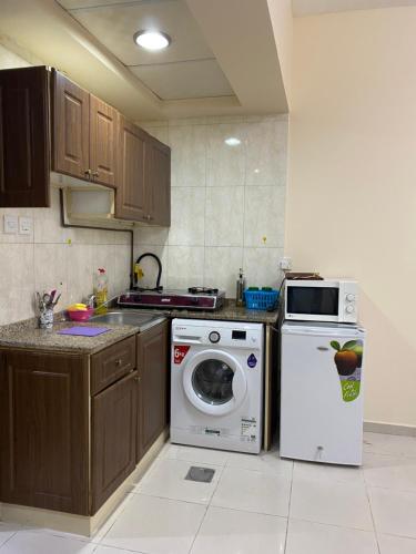 沙迦Entire Studio Flat in Sharjah.的厨房配有炉灶和洗衣机。