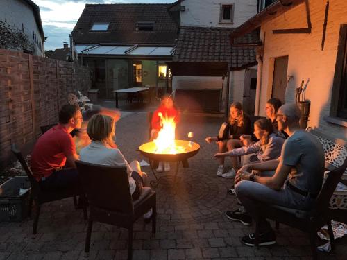 奥德纳尔德Enjoytoday 49 - Luxueus familieverblijf aan de voet van de Koppenberg的一群人坐在院子里的火堆旁