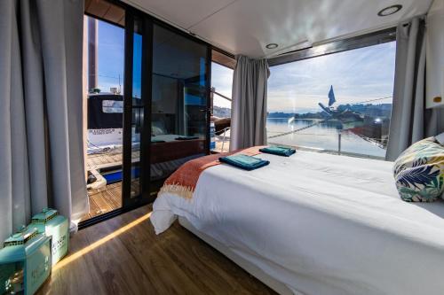 波尔图Oporto Douro Floating House的一张大床,位于带大窗户的房间里