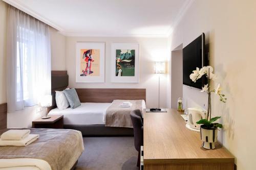 贝尔格莱德Hotel Opera Garni的配有一张床和一张书桌的酒店客房