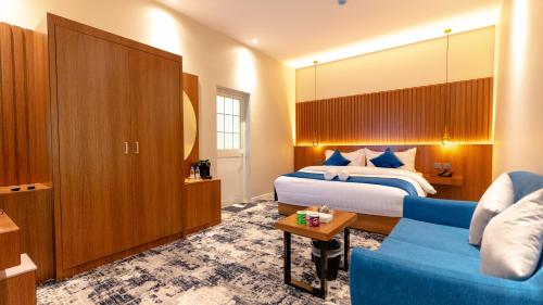 代瓦西尔干河فندق ارجان بارك Arjan Park Hotel的酒店客房,配有床和蓝色的沙发