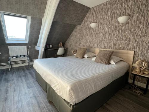 特鲁瓦托耶酒店的一间卧室,卧室内配有一张大床