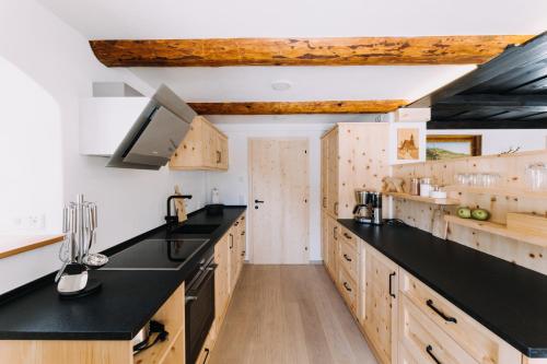库罗阿尔滕堡Erzgebirgshaus的厨房配有黑色台面和木制橱柜