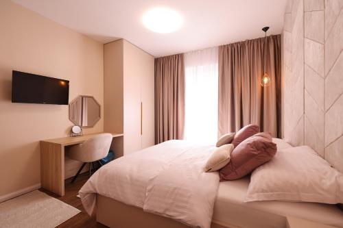 Donji ZemunikD-Palace-Adriatic的配有一张床和一张书桌的酒店客房