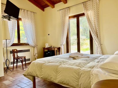 萨杜勒尼亚Casale Terre Rosse的一间卧室设有一张大床和一个窗户。