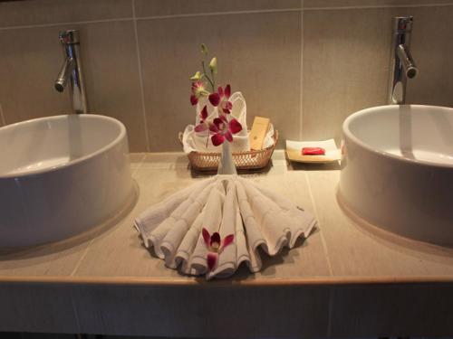 波普托The Waterfront Hotel at Fishermans Village的浴室柜台设有两个盥洗盆和一个花瓶