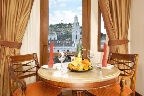 基多广场大酒店的一张桌子,放着一碗水果,享有城市美景