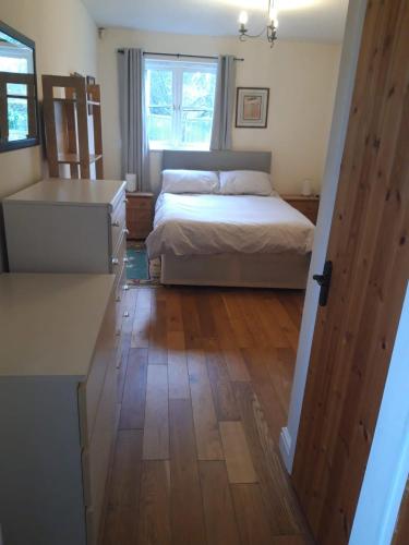坎特伯雷Little Orchard Cottage的一间卧室配有一张床,铺有木地板