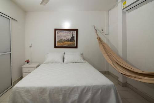 蒙特里亚Acogedor Apartamento en el Norte 3 Habitaciones F14B的卧室配有一张白色床,墙上挂着一幅画
