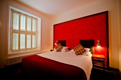 邓加文唐纳利旅馆的一间卧室配有一张大床和红色床头板