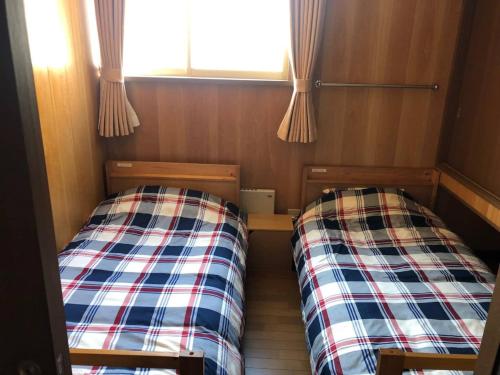 钏路Guest House Nusa - Vacation STAY 12651的小型客房 - 带2张床和窗户