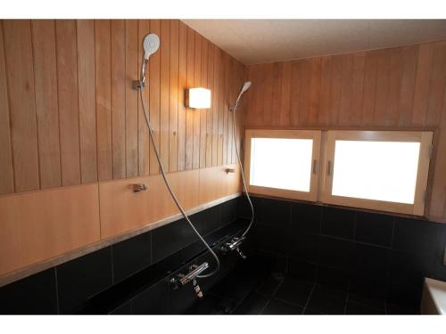 钏路Guest House Tou - Vacation STAY 26345v的带淋浴和盥洗盆的浴室以及2扇窗户。