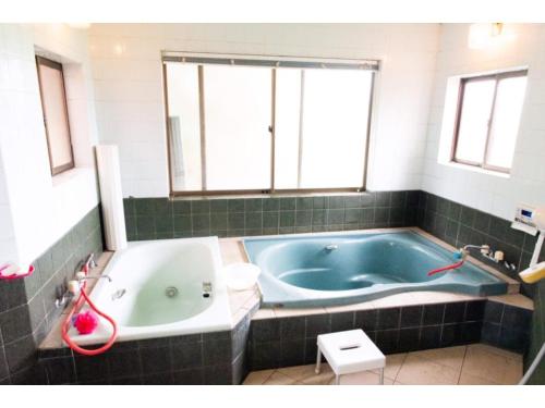 壹岐市Asobiyahouse Iki - Vacation STAY 30413v的一间带蓝色浴缸和窗户的浴室