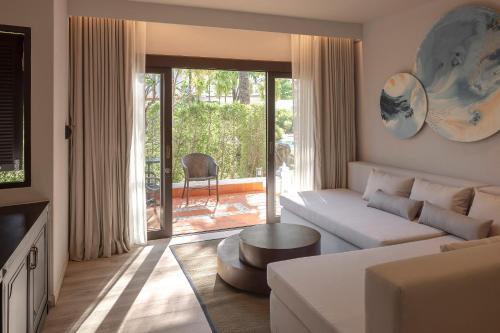 卡马拉海滩The Pe La Resort, Phuket - SHA Extra Plus的客厅配有沙发和桌子