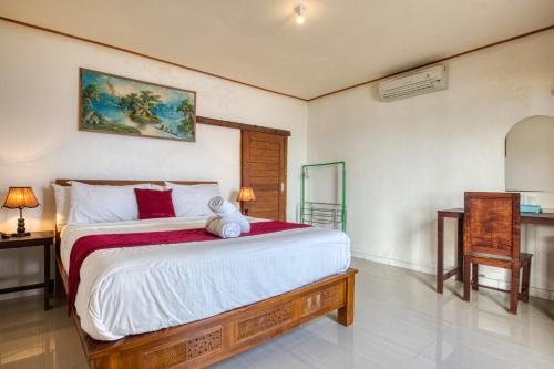 珀尼达岛Sari Nadi Beach的一间卧室配有一张大床和一张桌子