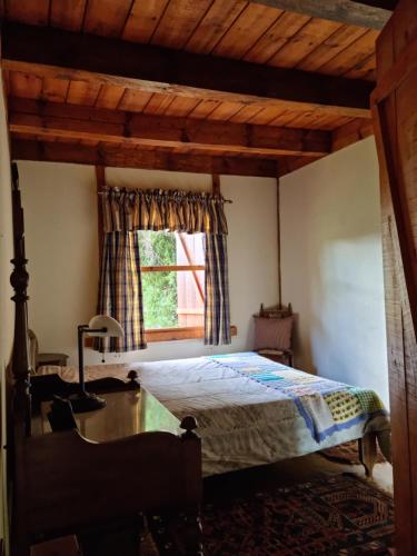 坎波斯杜若尔当Chalé na Serra da Mantiqueira的一间卧室设有一张床和一个窗口