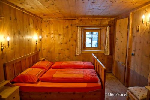 利维尼奥Bed & Breakfast Campaciol的木制客房内的一间卧室,配有一张床