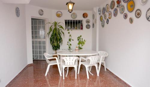 塞维利亚Casa Soleada en Calle Tranquila的一间配备有白色桌椅的用餐室