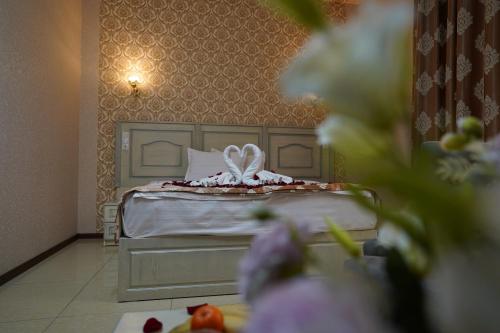 塔什干Sofiya Tashkent Hotel的卧室配有一张带白色枕头的床