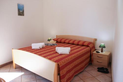 梵蒂冈角Hotel L'Ancora的一间卧室配有一张红色和橙色床罩的床