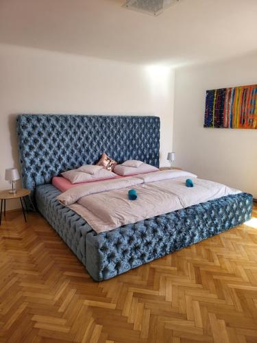 上布罗德Vila Quantum Bohemia的一张大床,在房间内有一个蓝色床头板