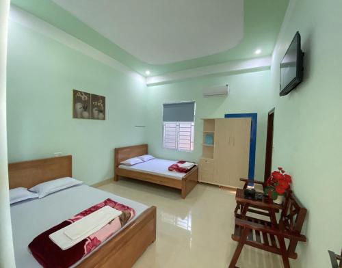 An Bình (1)MINH THU MOTEL的一间卧室配有一张床、一张书桌和一台电视。