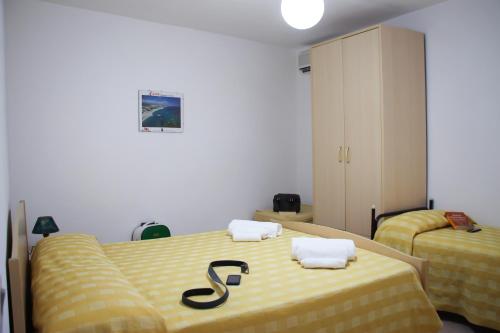 梵蒂冈角Hotel L'Ancora的一间卧室配有两张带黄床单的床