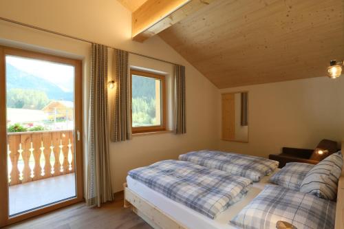QuinzoFerienwohnungen Unterangerhof的一间带两张床的卧室和一个阳台