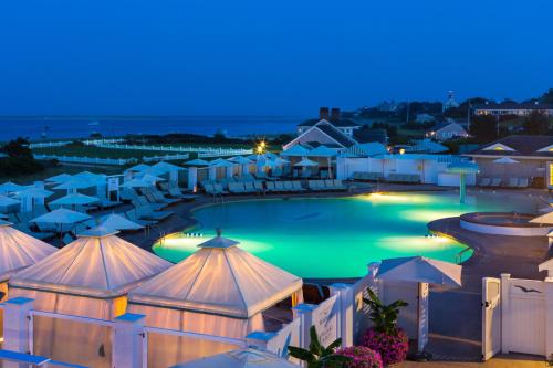 查塔姆查塔姆巴尔斯酒店的享有游泳池的景色,晚上配有遮阳伞