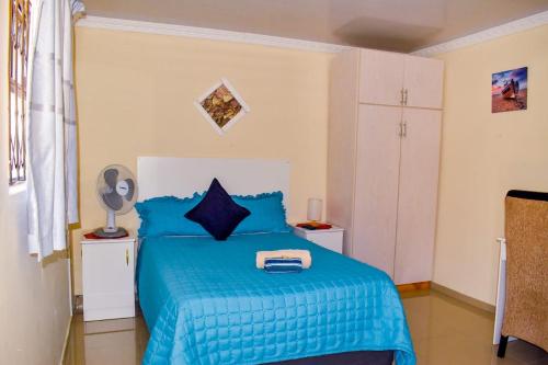 斯坦格Gabade Guest House的一间卧室配有蓝色的床和蓝色的毯子