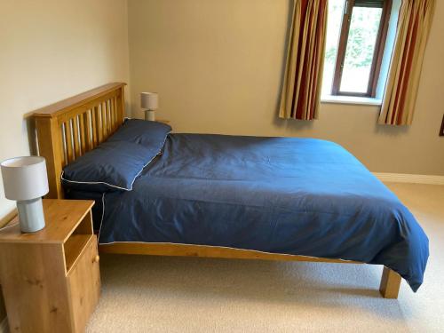 科克Beautiful & Quiet Countryside Setting in Kinsale的一间卧室配有一张带蓝色棉被的床