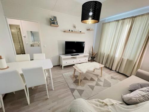 科特卡Ilona Apartments - "The City Condo"的一间带桌子的客厅和一间带电视的客厅