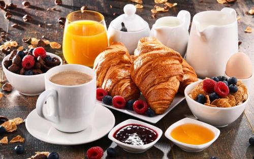 加斯佩里纳Alepou Guest House的一张桌子,早餐包括羊角面包、咖啡和水果