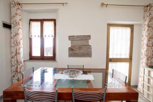 瑟克罗Sulla Valle di Seccheto的一间设有玻璃桌和椅子的用餐室
