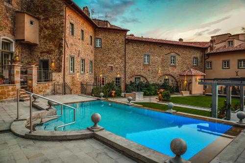 科尔托纳Monastero Di Cortona Hotel & Spa的大楼前的游泳池