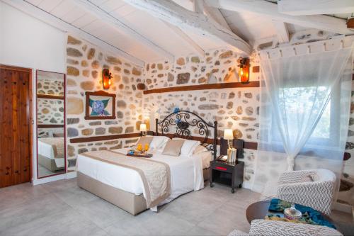 埃利亚Acrotel Athena Residence的卧室配有白色的床和石墙