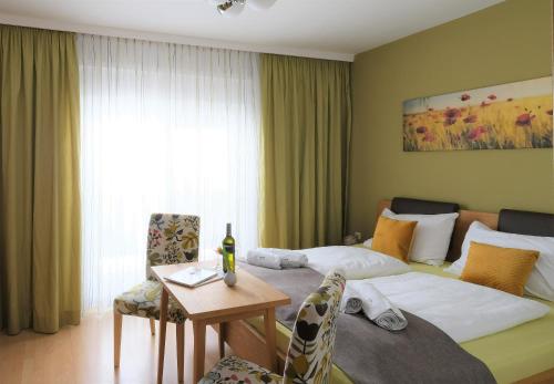 约伊斯Winzerhof Lentsch的酒店客房配有一张床铺和一张桌子。