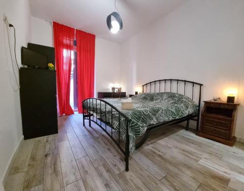 佛罗伦萨Kos的一间卧室配有一张床、一张桌子和红色窗帘