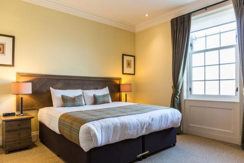 巴洛赫Cameron Club Lodges的一间卧室设有一张大床和一个窗户。