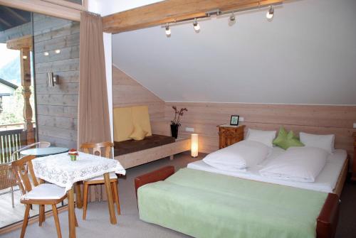迈尔霍芬施赛布兰德勒旅馆的一间卧室配有一张床和一张桌子及一张桌子