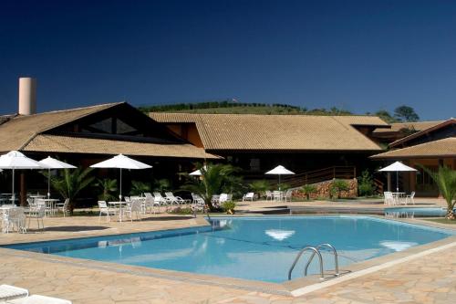 安帕鲁坎托达斯塔环保度假村的度假村前的游泳池配有椅子和遮阳伞