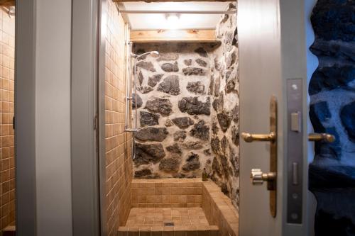 Flatey商人酒店的带淋浴的浴室(带石墙)