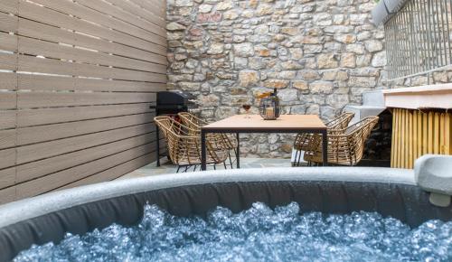 纳弗帕克托斯Lepanto Luxury Apartments GF的庭院内的游泳池,配有桌椅