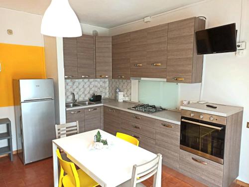 切齐纳码头Casa Prati的带白色桌子的厨房和带冰箱的厨房