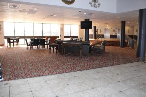 黑格斯敦Apm Inn & Suites的大房间设有钢琴和桌椅