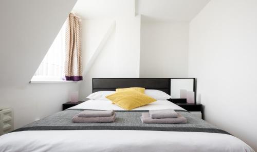 伦敦霍斯顿中央肖迪奇酒店的一间卧室配有一张床,上面有两条毛巾
