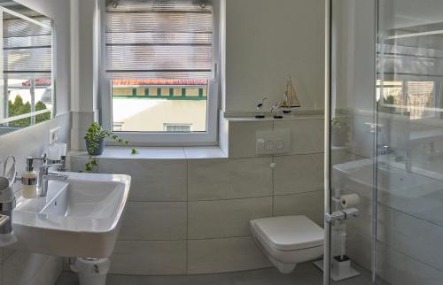 HerbslebenAn der Linde的一间带水槽和卫生间的浴室以及窗户。